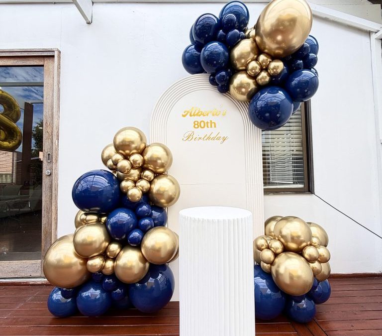 A Navy Blue and Gold Balloon Backdrop for an Elegant Birthday Celebration