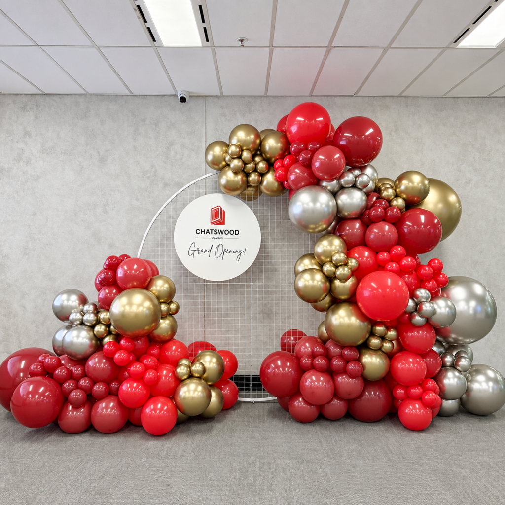 Grand Opening Balloon Decoration with red and gold balloon garlands, circular backdrop and custom Chatswood Campus signage